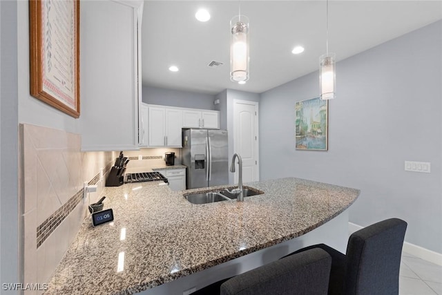 20147 Torch Key Way, Estero, FL 33928 - kitchen featuring stainless steel fridge with ice dispenser, light stone countertops, white cabinetry, a peninsula, and hanging light fixtures