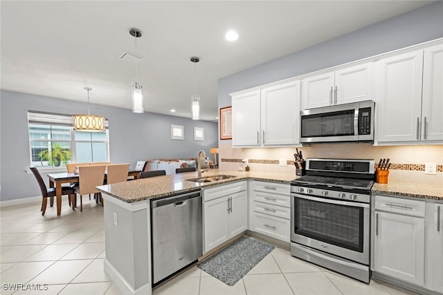 20147 Torch Key Way, Estero, FL 33928 - kitchen featuring stainless steel appliances, a peninsula, white cabinets, recessed lighting, and light stone countertops