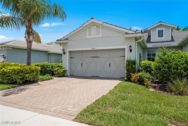 20147 Torch Key Way, Estero, FL 33928 - single story home with a garage, stucco siding, and decorative driveway
