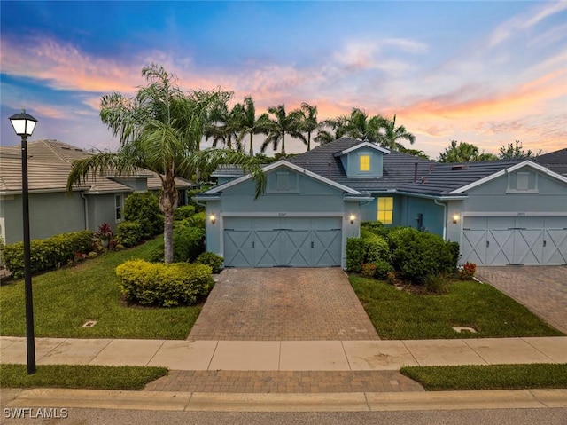 20147 Torch Key Way, Estero, FL 33928 - view of front of property featuring an attached garage, decorative driveway, stucco siding, and a front lawn