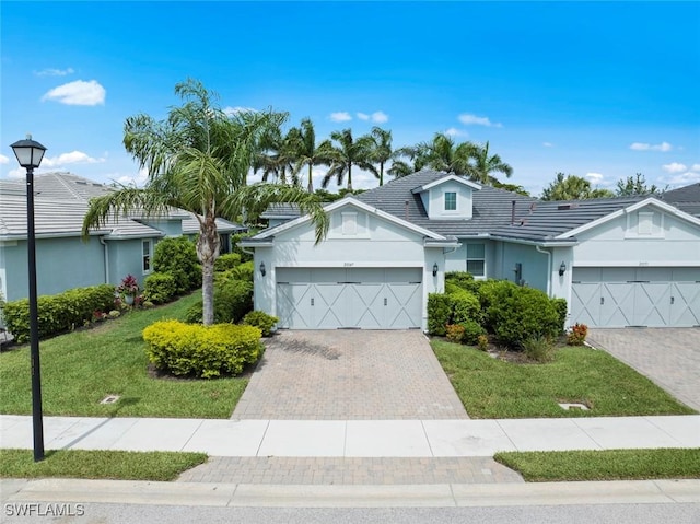 20147 Torch Key Way, Estero, FL 33928 - single story home featuring a garage, stucco siding, decorative driveway, and a front yard