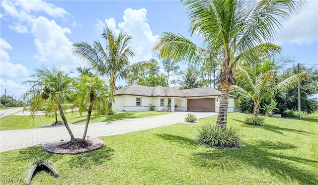 1700 E 15th St, Lehigh Acres, FL 33972 - ranch-style home featuring decorative driveway, a garage, a front yard, and stucco siding