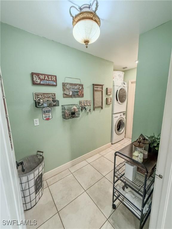 1700 E 15th St, Lehigh Acres, FL 33972 - laundry room with stacked washing machine and dryer and light tile patterned flooring