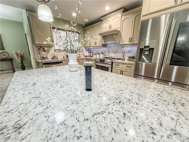 1700 E 15th St, Lehigh Acres, FL 33972 - kitchen featuring appliances with stainless steel finishes, tasteful backsplash, light stone counters, recessed lighting, and hanging light fixtures