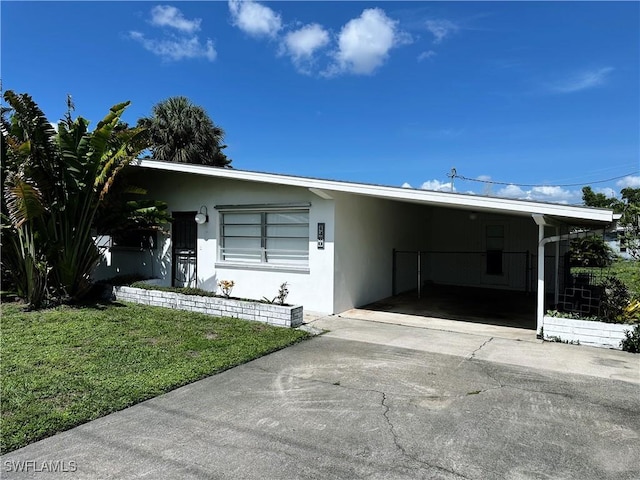 4360 Deleon St, Fort Myers, FL 33901 - view of front of house with stucco siding, a front lawn, driveway, and an attached carport