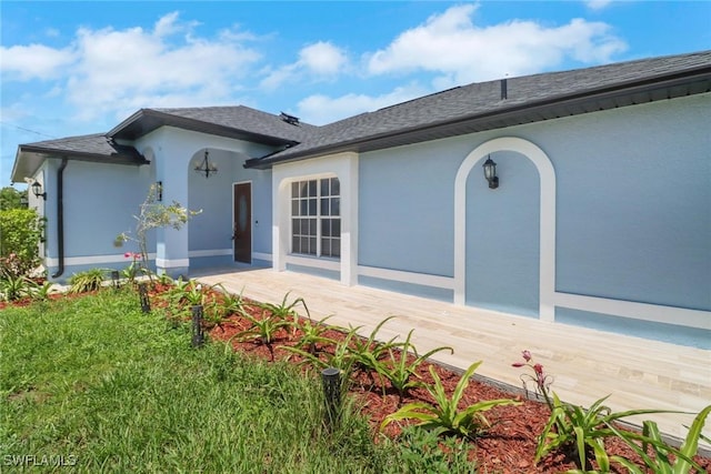 765 Aprile Ave S, Lehigh Acres, FL 33974 - view of front facade featuring stucco siding and roof with shingles