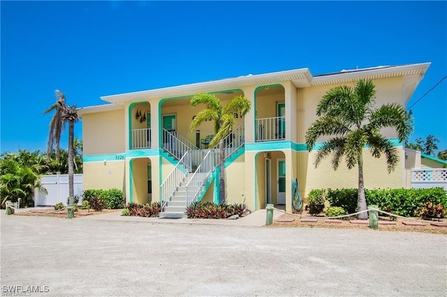 3226 Stringfellow Rd, Saint James City, FL 33956 - view of front of house featuring stairs, stucco siding, and covered porch
