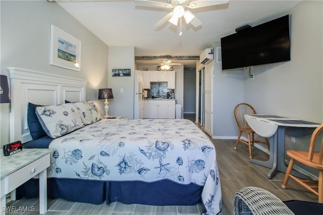 3226 Stringfellow Rd, Saint James City, FL 33956 - bedroom featuring a wall mounted AC, wood finished floors, freestanding refrigerator, and ceiling fan
