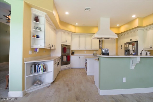 19801 N River Rd, Alva, FL 33920 - kitchen with stainless steel fridge, island range hood, open shelves, multiple ovens, and light countertops