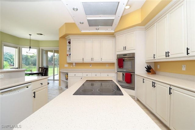 19801 N River Rd, Alva, FL 33920 - kitchen with white dishwasher, black electric stovetop, stainless steel double oven, hanging light fixtures, and white cabinets