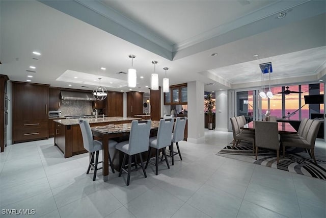 10 Seagate Dr Unit 10N, Naples, FL 34103 - dining space featuring a tray ceiling, crown molding, recessed lighting, light tile patterned flooring, and a chandelier