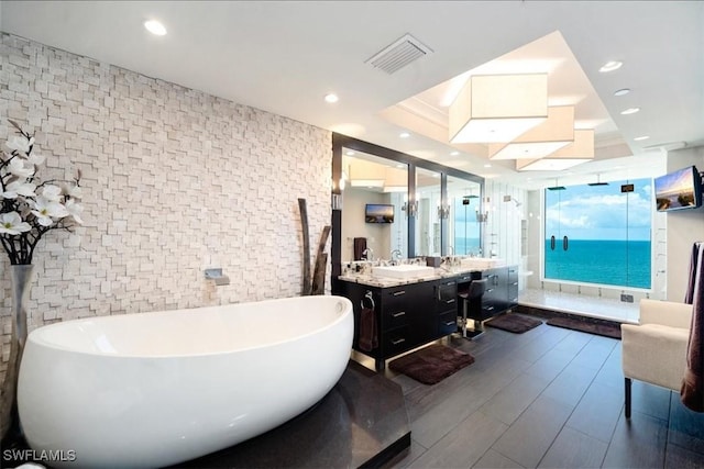 10 Seagate Dr Unit 10N, Naples, FL 34103 - bathroom with a freestanding bath, vanity, a stall shower, wood finished floors, and recessed lighting