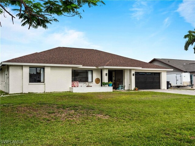 17577 Moorfield Dr, Fort Myers, FL 33908 - rear view of property with concrete driveway, a garage, a yard, and stucco siding
