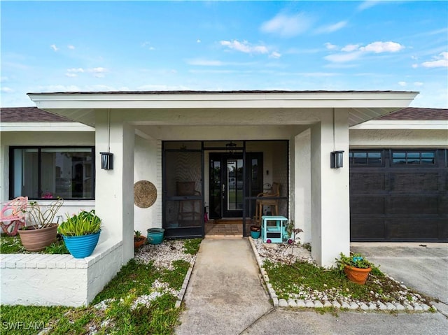 17577 Moorfield Dr, Fort Myers, FL 33908 - view of exterior entry with an attached garage, stucco siding, covered porch, and roof with shingles