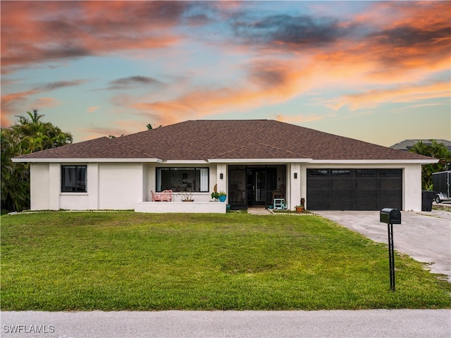 17577 Moorfield Dr, Fort Myers, FL 33908 - view of front facade featuring a garage, driveway, a front lawn, and stucco siding