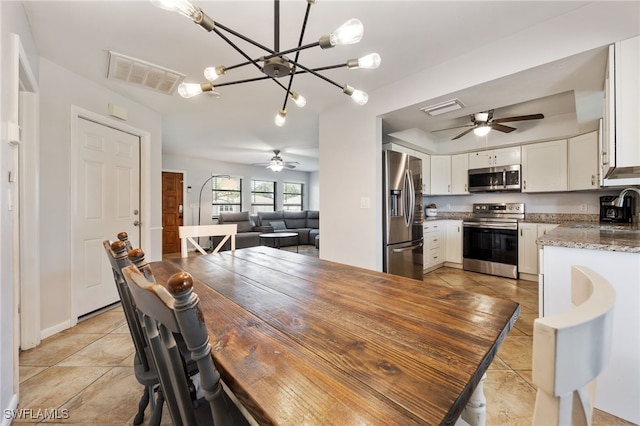 1831 SE 6th St, Cape Coral, FL 33990 - dining room with ceiling fan, light tile patterned floors, and a chandelier