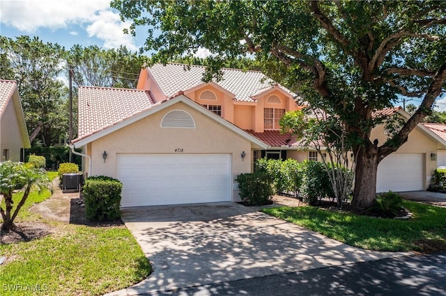 4718 Via Carmen, Naples, FL 34105 - mediterranean / spanish-style home featuring a tiled roof, stucco siding, a garage, and driveway