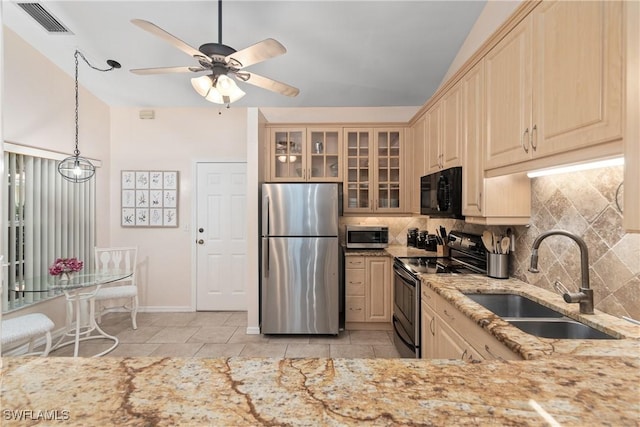 4718 Via Carmen, Naples, FL 34105 - kitchen with appliances with stainless steel finishes, decorative backsplash, glass insert cabinets, and light stone counters