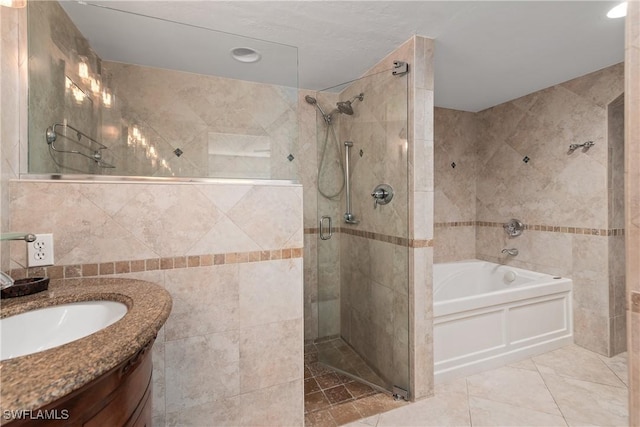 4718 Via Carmen, Naples, FL 34105 - bathroom featuring tile walls, a shower stall, vanity, a garden tub, and tile patterned flooring