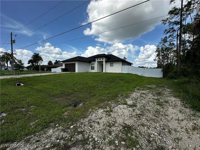 904 James Ave, Lehigh Acres, FL 33936 - view of side of property featuring a garage, driveway, and stucco siding