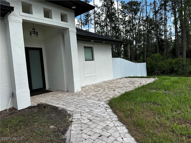 904 James Ave, Lehigh Acres, FL 33936 - doorway to property with stucco siding and a patio