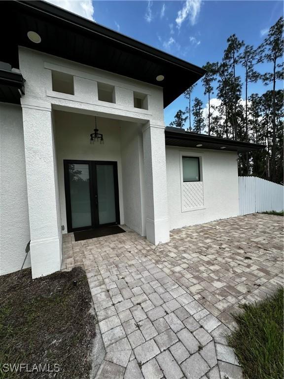 904 James Ave, Lehigh Acres, FL 33936 - entrance to property featuring stucco siding, french doors, and a patio