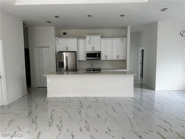 904 James Ave, Lehigh Acres, FL 33936 - kitchen with stainless steel appliances, an island with sink, white cabinets, and light marble finish flooring