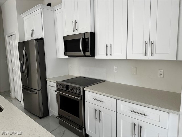 904 James Ave, Lehigh Acres, FL 33936 - kitchen with appliances with stainless steel finishes, light marble finish floors, white cabinetry, and light stone countertops