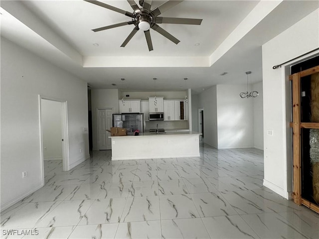 904 James Ave, Lehigh Acres, FL 33936 - unfurnished living room with a raised ceiling, ceiling fan, and light marble finish flooring