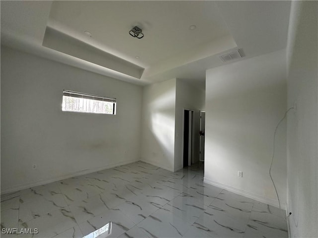 904 James Ave, Lehigh Acres, FL 33936 - unfurnished room featuring a tray ceiling and light marble finish flooring