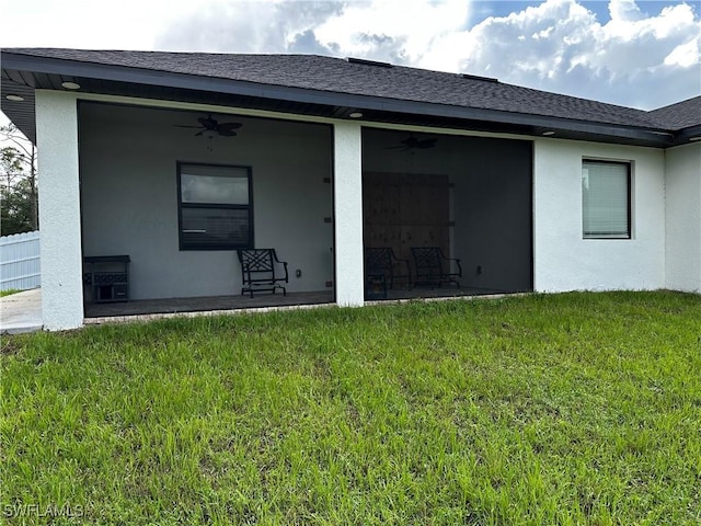 904 James Ave, Lehigh Acres, FL 33936 - rear view of house with ceiling fan, a lawn, and roof with shingles