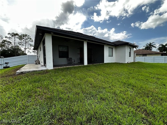 904 James Ave, Lehigh Acres, FL 33936 - back of property featuring a fenced backyard, stucco siding, and a patio