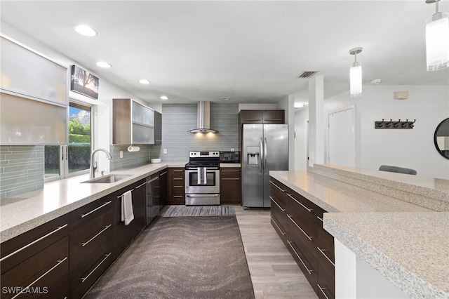 134 Palm River Blvd, Naples, FL 34110 - kitchen with appliances with stainless steel finishes, wall chimney exhaust hood, light countertops, tasteful backsplash, and light wood finished floors