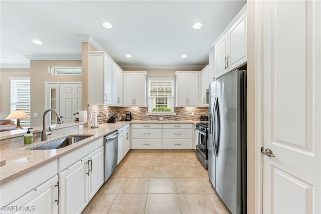 8257 Lucello Ter W, Naples, FL 34114 - kitchen with stainless steel appliances, crown molding, backsplash, white cabinets, and light stone counters