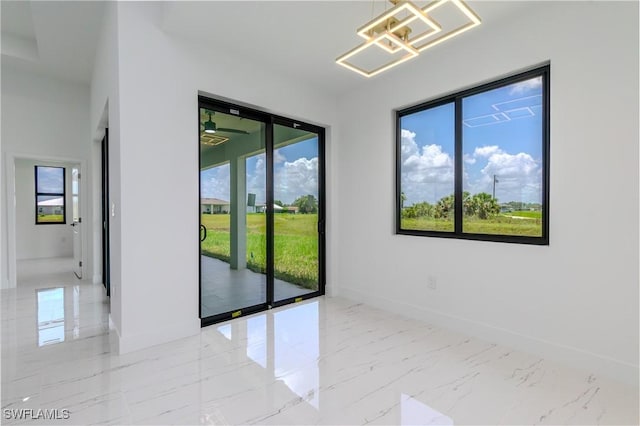 1144 Monday St, Labelle, FL 33935 - empty room featuring healthy amount of natural light, light marble finish floors, and a chandelier