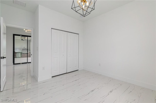 1144 Monday St, Labelle, FL 33935 - unfurnished bedroom featuring marble look tile flooring, a chandelier, and a closet