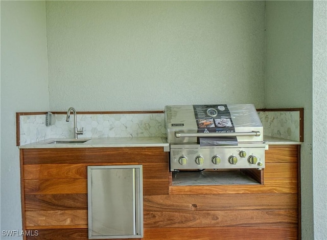 1144 Monday St, Labelle, FL 33935 - kitchen featuring brown cabinetry, light countertops, modern cabinets, and a textured wall