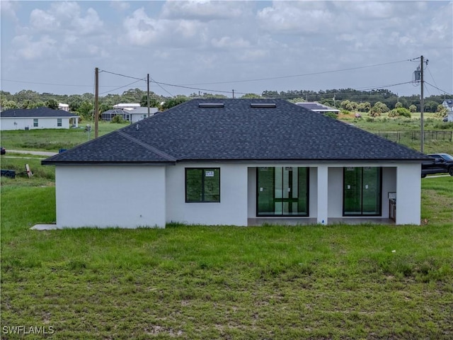 1144 Monday St, Labelle, FL 33935 - back of house featuring a shingled roof, stucco siding, and a lawn