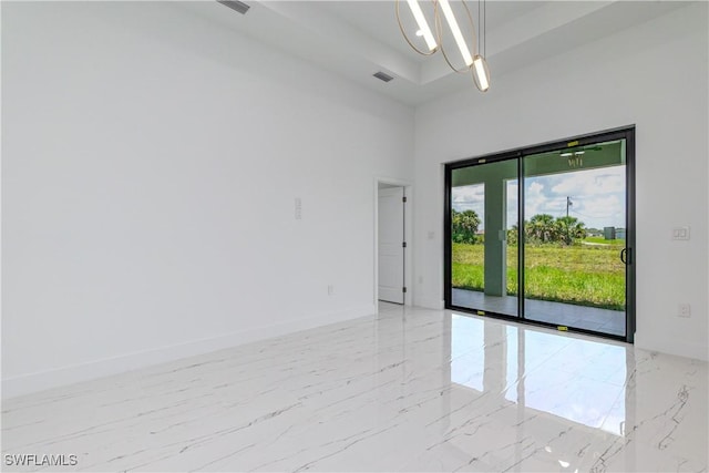 1144 Monday St, Labelle, FL 33935 - spare room featuring light marble finish floors, a high ceiling, and a chandelier