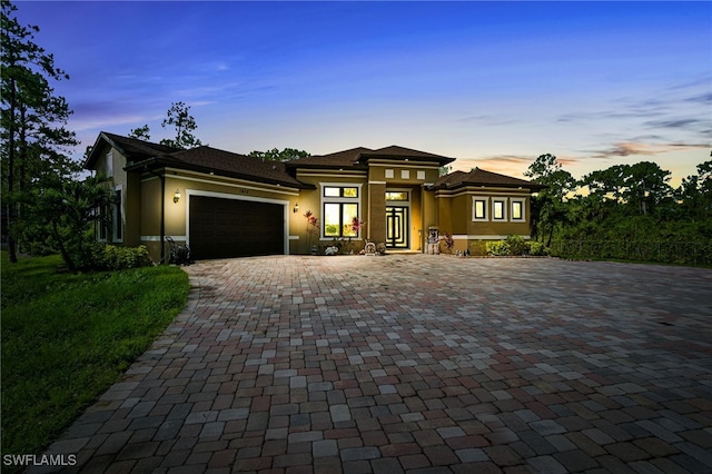 1912 Jung Blvd E, Naples, FL 34120 - prairie-style home with stucco siding, a garage, and decorative driveway