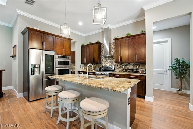 1912 Jung Blvd E, Naples, FL 34120 - kitchen with stainless steel appliances, wall chimney range hood, tasteful backsplash, light wood-style flooring, and crown molding