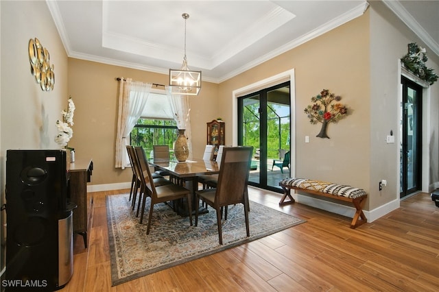 1912 Jung Blvd E, Naples, FL 34120 - dining area with a chandelier, light wood-style flooring, a tray ceiling, and crown molding
