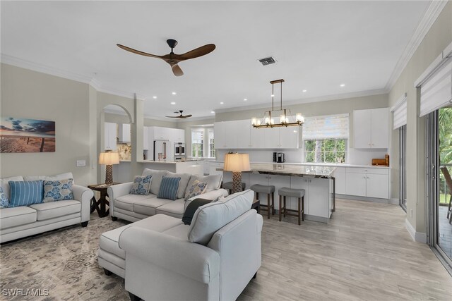 5040 Yacht Harbor Cir Unit 6, Naples, FL 34112 - living room featuring ceiling fan, healthy amount of natural light, light wood-style floors, crown molding, and a chandelier