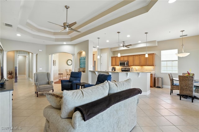 178 Shadroe Cove Cir Unit 903, Cape Coral, FL 33991 - living room featuring arched walkways, ceiling fan, a raised ceiling, crown molding, and light tile patterned floors