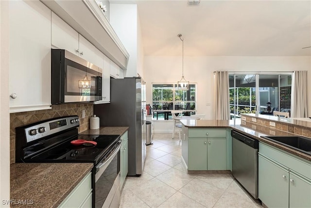 6769 Berwick Pl, Naples, FL 34104 - kitchen with appliances with stainless steel finishes, green cabinetry, dark countertops, light tile patterned floors, and tasteful backsplash