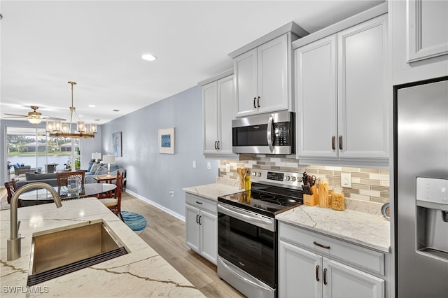 14803 Edgewater Cir, Naples, FL 34114 - kitchen featuring stainless steel appliances, tasteful backsplash, light wood-style flooring, light stone countertops, and recessed lighting