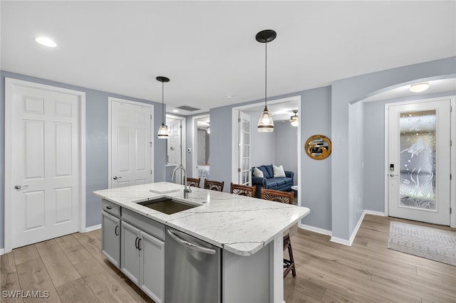 14803 Edgewater Cir, Naples, FL 34114 - kitchen featuring stainless steel dishwasher, light wood-style floors, arched walkways, pendant lighting, and recessed lighting