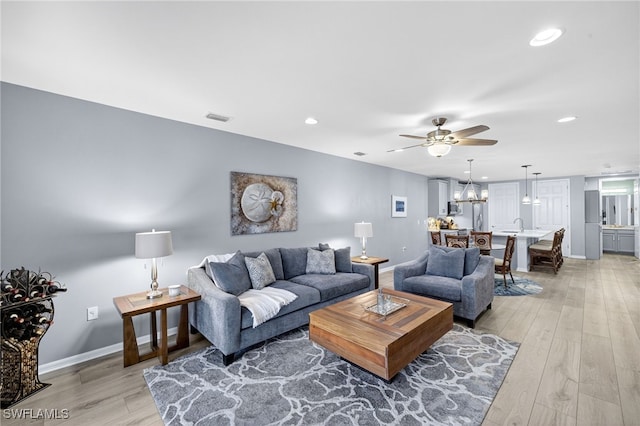 14803 Edgewater Cir, Naples, FL 34114 - living room featuring a ceiling fan, light wood-style flooring, a chandelier, and recessed lighting