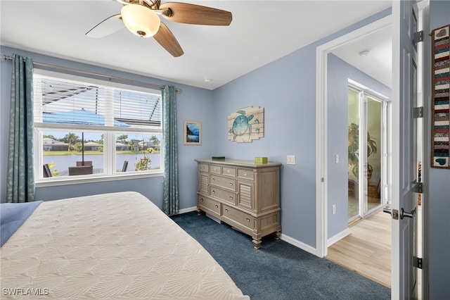 14803 Edgewater Cir, Naples, FL 34114 - carpeted bedroom with fridge, a ceiling fan, and a water view