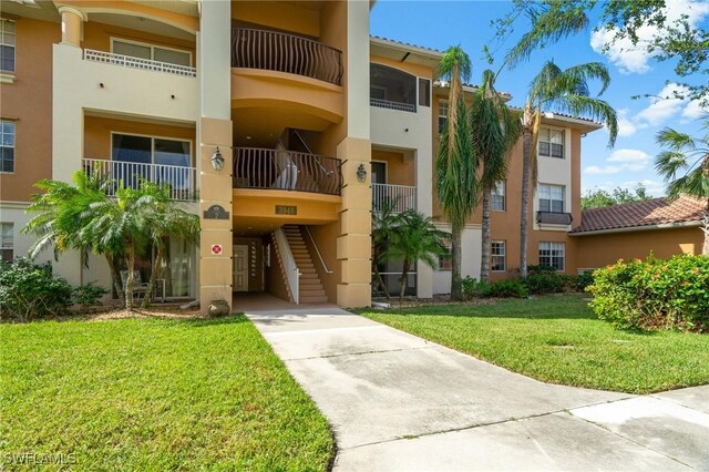 3948 Pomodoro Cir Unit 102, Cape Coral, FL 33909 - view of building exterior featuring driveway, stairs, and a carport
